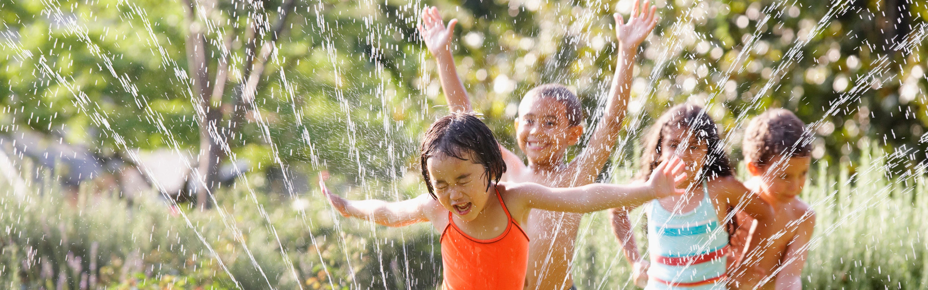 Kids running through sprinklers