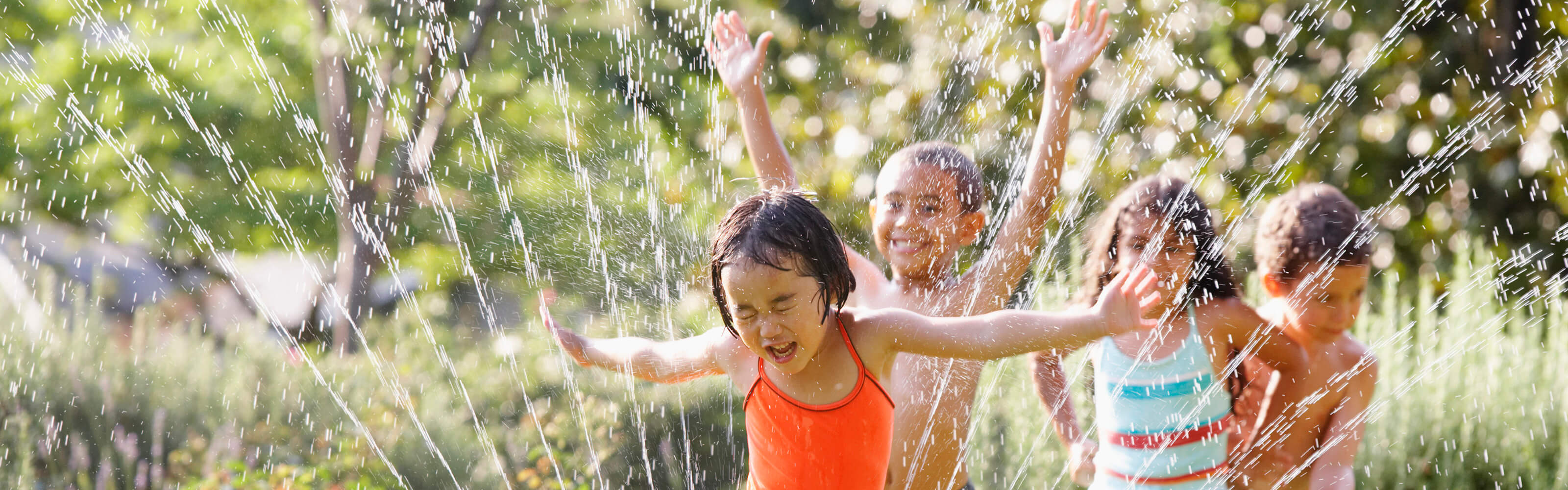 Kids running through sprinklers
