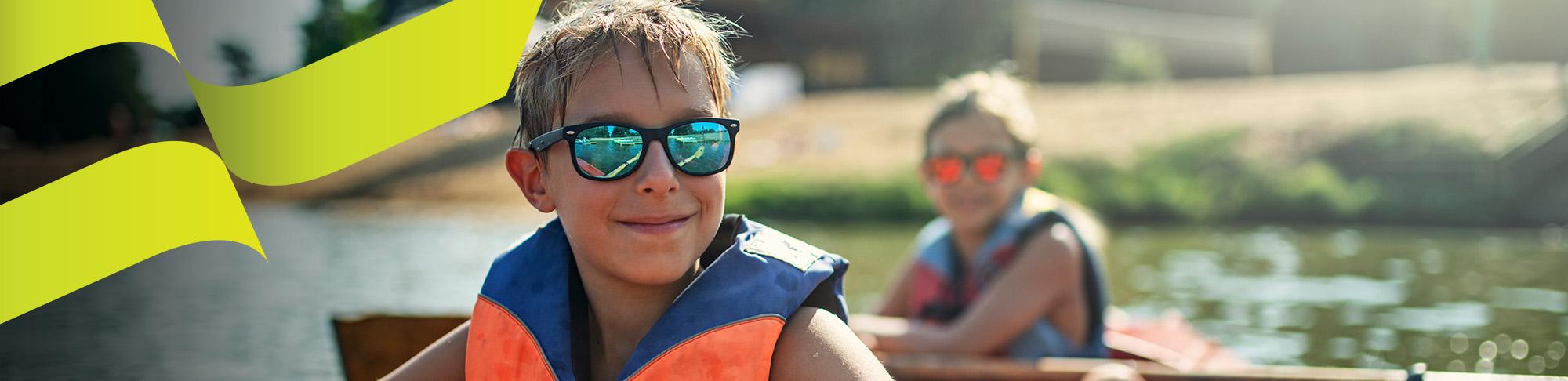 Two kids on a kayak with sunglasses - AU Desktop Summer Banner