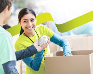 volunteer handing another volunteer a canned good