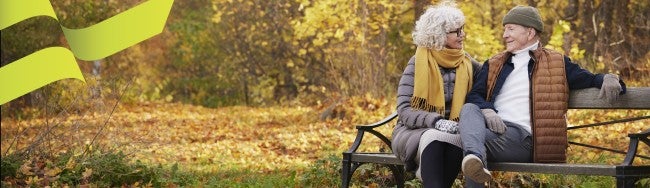 elderly couple sitting on a park bench